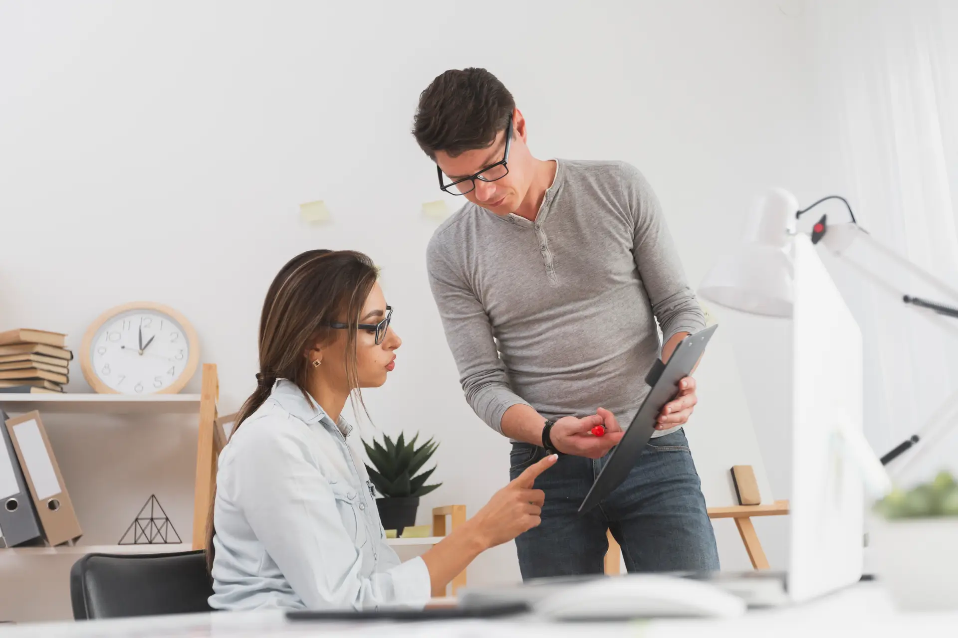 man showing data from clipboard business woman