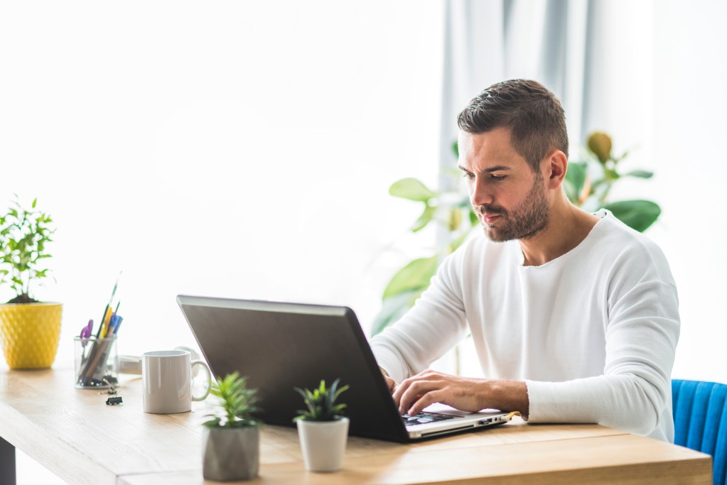 man at table working on a laptop